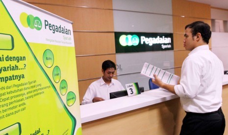 Petugas melayani nasabah di kantor Pegadaian Syariah, Jakarta, Senin (8/12).