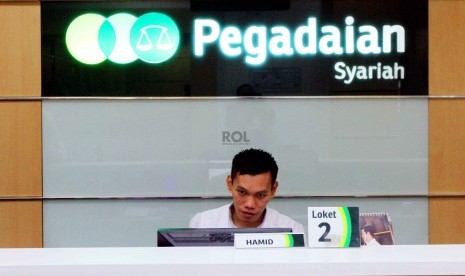 Petugas melayani nasabah di kantor Pegadaian Syariah, Jakarta, Senin (8/12).