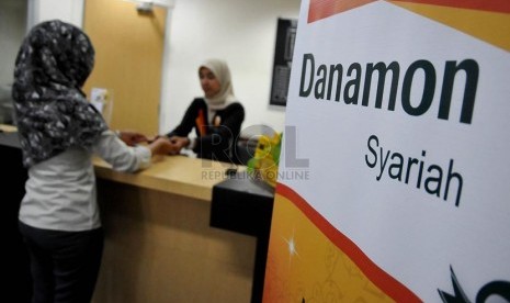 Petugas melayani nasabah di salah satu kantor cabang Bank Danamon Syariah di Jakarta, Jumat (22/8).(Prayogi/Republika)