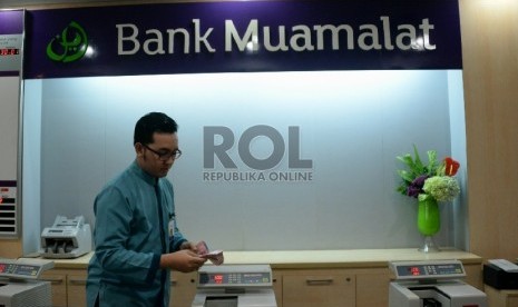 Petugas melayani nasabah di salah satu kantor cabang Bank Muamalat, Jakarta, Selasa (10/3).