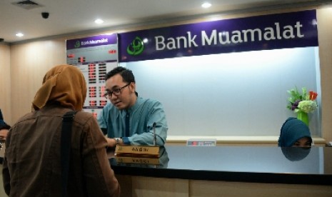 Petugas melayani nasabah di salah satu kantor cabang Bank Muamalat, Jakarta, Selasa (10/3).