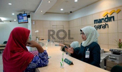 Petugas melayani nasabah di salah satu kantor cabang Bank Syariah Mandiri, Jakarta, Kamis (21/5).