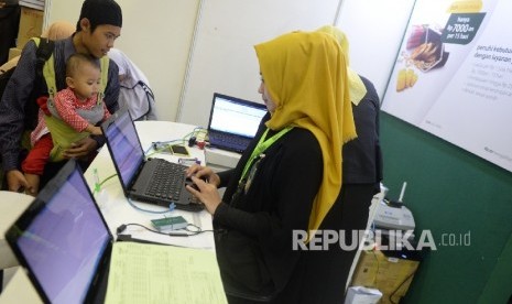  Petugas melayani nasbah di kantor layanan Bank Syariah Mandiri, Jakarta, Ahad (7/5)