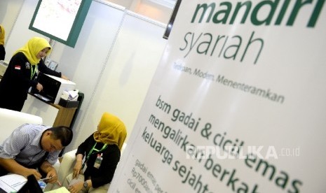 Petugas melayani nasabah di kantor layanan Bank Syariah Mandiri, Jakarta, Ahad (7/5).