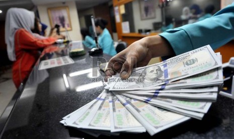 Petugas melayani penukaran uang dolar