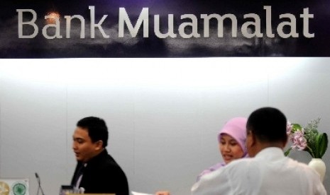 Petugas melayani transaksi nasabah di kantor layanan Bank Muamalat, Jakarta, Kamis (8/11).