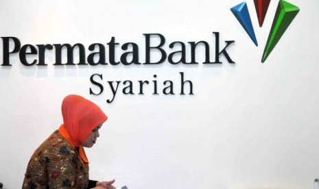 Petugas melayani transaksi nasabah di kantor layanan Bank Permata Syariah, Jakarta, Jumat (23/5).