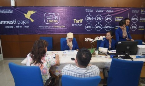 Petugas melayani wajib pajak untuk memperoleh informasi mengenai kebijakan amnesti pajak (tax amnesty) di Help Desk Kantor Wilayah Direktorat Jenderal Pajak I, Jakarta Selatan, Senin (19/9).