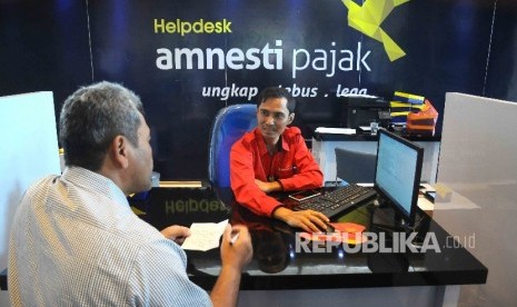 Petugas melayani wajib pajak yang ingin memperoleh informasi mengenai kebijakan amnesti pajak (tax amnesty) di Help Desk, di Gedung Direktorat Jenderal Pajak, Jakarta Pusat, Kamis (8/12). 