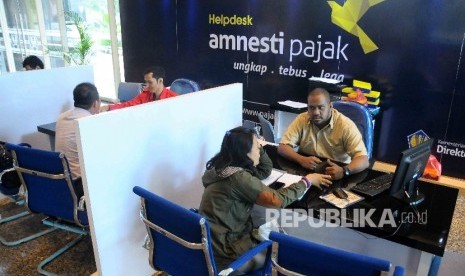 Petugas melayani wajib pajak yang ingin memperoleh informasi mengenai kebijakan amnesti pajak (tax amnesty) di Help Desk, di Gedung Direktorat Jenderal Pajak, Jakarta Pusat, Kamis (8/12).