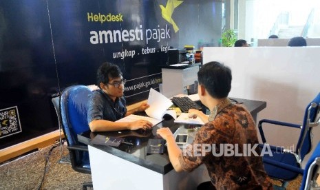 Petugas melayani wajib pajak yang ingin memperoleh informasi mengenai kebijakan amnesti pajak (tax amnesty) di Help Desk, di Gedung Direktorat Jenderal Pajak, Jakarta Pusat, Kamis (8/12). 