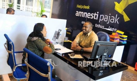 Petugas melayani wajib pajak yang ingin memperoleh informasi mengenai kebijakan amnesti pajak (tax amnesty) di Help Desk, di Gedung Direktorat Jenderal Pajak, Jakarta Pusat, Kamis (8/12).