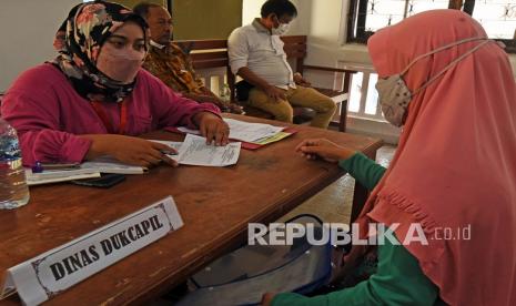 Petugas melayani warga korban banjir saat mengurus pembaharuan dokumen yang rusak (ilustrasi).