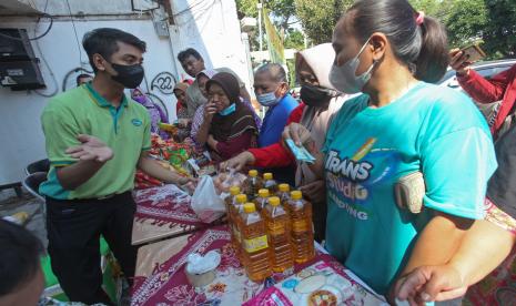 Petugas melayani warga yang antre membeli bahan pangan saat digelarnya pasar murah di Jalan Undaan Wetan, Surabaya, Jawa Timur, Jumat (2/9/2022). Pemkot Surabaya menggelar pasar murah di sejumlah lokasi di Surabaya untuk menstabilkan harga sejumlah bahan pangan. 