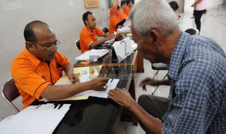   Petugas melayani warga yang mengambil uang Bantuan Langsung Sementara Masyarakat (BLSM) di Jakarta, Sabtu (22/6).  (Republika/Aditya Pradana Putra)