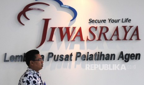 Petugas melintas di depan logo PT Asuransi Jiwasraya.