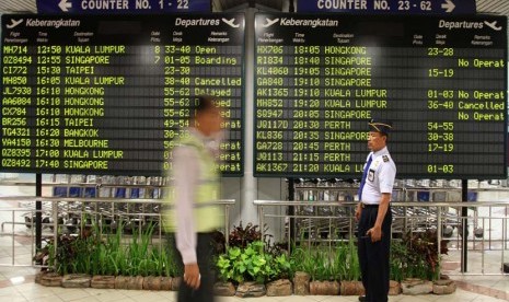  Petugas melintas di depan papan pemberitahuan keberangkatan pesawat di Bandara Ngurah Rai, Denpasar, Bali (ilustrasi) 