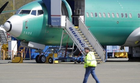 Petugas melintas di depan pesawat Boeing 737 MAX 8 yang tengah dibuat untuk Oman Air di fasilitas perakitan Boeing di Renton, Washington, Amerika Serikat. Federal Aviation Administration (FAA) menerbitkan sertifikat kelaikudaraan baru untuk pesawat Boeing 737 Max.