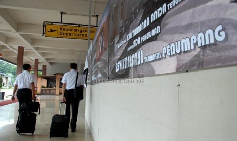  Petugas melintas di depan ruang 'check in' yang tengah dalam perbaikan di Bandar Udara Halim Perdanakusuma, Jakarta Timur, Jumat (20/12).  (Republika/Rakhmawaty La'lang)