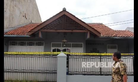 Petugas melintas di depan rumah tempat ditemukan dugaan limbah zat radioaktif di Kompleks Batan Indah Blok A, Serpong, Tangerang Selatan, Banten, Senin (24/2/2020).