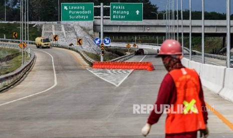 Petugas melintas di tol Singosari yang belum beroperasi di Malang, Jawa Timur, Minggu (12/5/2019). Ruas Tol Pandaan-Malang seksi I-III dari Pandaan-Singosari sepanjang 31 Km itu diharapkan akan memperlancar arus mudik Lebaran 2019 di Jawa Timur. 