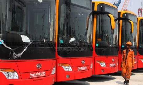  Petugas melintasi bus TransJakarta gandeng bekas dari Cina di Pelabuhan Tanjung Priok, Jakarta, Kamis (5/12). (Republika/Yasin Habibi)