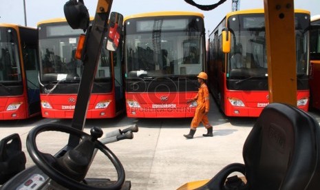  Petugas melintasi bus TransJakarta gandeng bekas dari Cina di Pelabuhan Tanjung Priok, Jakarta, Kamis (5/12). (Republika/Yasin Habibi)