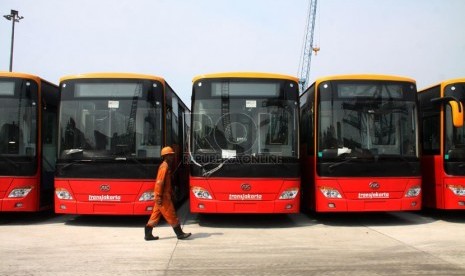  Petugas melintasi bus TransJakarta gandeng bekas dari Cina di Pelabuhan Tanjung Priok, Jakarta, Kamis (5/12). (Republika/Yasin Habibi)