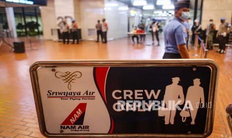 Petugas melintasi logo perusahaan angkutan udara Sriwijaya dan NAM Air di Posko Crisis Center Sriwijaya Air SJ 182 Terminal 2D Bandara Soekarno-Hatta, Tangerang, Banten, Sabtu (9/1/2021). Posko tersebut didirikan untuk memberikan informasi bagi keluarga korban pesawat Sriwijaya Air SJ 182 rute Jakarta-Pontianak yang hingga kini masih hilang kontak. 