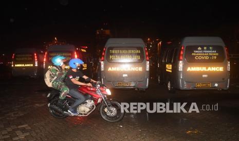 Petugas melintasi mobil ambulans di Dermaga Pelabuhan JICT 2, Jakarta, Sabtu (9/1/2021). Kegiatan tersebut untuk persiapan proses pencarian pesawat Sriwijaya Air SJ 182 yang hilang kontak di perairan Kepulauan Seribu.