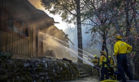 Petugas memadamkan api di sebuah rumah Sonoma County, California, Amerika, Selasa (29/10).