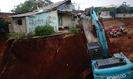 Petugas memakai alat berat merobohkan bangunan yang terdampak pembagunan Tol Cijago di Jalan Juanda Depok, Jawa Barat, Senin (10/12/2018).