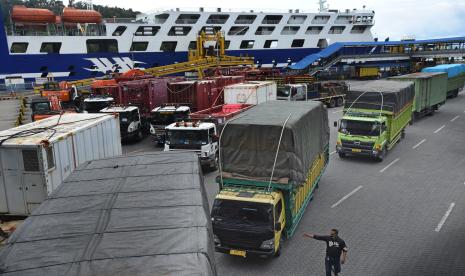 Petugas memandu antrean truk yang akan menyeberang ke Sumatera di Dermaga V Pelabuhan Merak, Banten.