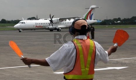   Petugas memandu pesawat yang mendarat di Bandara Halim Perdana Kusuma, Jakarta, Selasa (7/1).    (Republika/Yasin Habibi)