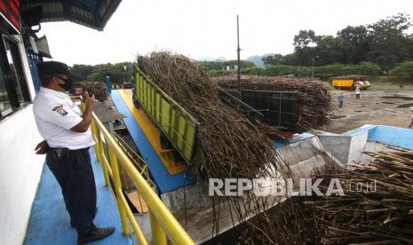 Petugas memantau aktivitas truk pengangkut tebu yang bongkar muatan di Pabrik Gula Glenmore, PTPN XII, Banyuwangi, Jawa Timur, Rabu (9/6/2021). 