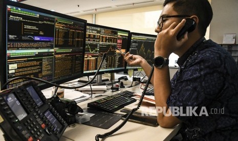 Petugas memantau grafik pergerakan penjualan Indeks Harga Saham Gabungan (IHSG) di Dealing Room Divisi Tresuri BNI, Jakarta, Jumat (27/9/2019).