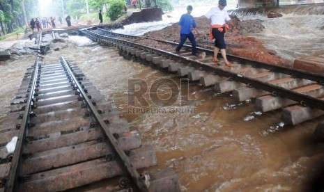  Petugas memantau rel kereta api yang terputus akibat luapan Kanal Banjir Barat di kawasan Taman Lawang, Menteng, Jakarta Pusat, Kamis (17/1).  (Republika/Aditya Pradana Putra)