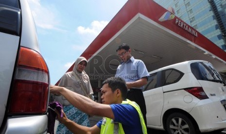   Petugas memasang alat radio frequency identification (RFID) tag pada kendaraan milik warga di SPBU milik Pertamina di Jalan Rasuna Said, Kuningan, Jakarta, Kamis (28/11).  (Republika/Aditya Pradana Putra)