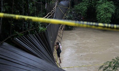 Petugas memasang police line di jembatan gantung yang roboh di Kampung Pekarungan, Serang , Selasa (21/1)