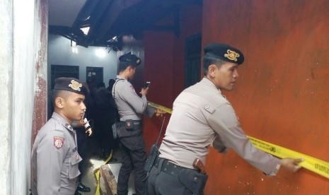 Petugas memasang garis polisi untuk menyegel rumah terduga teroris setelah penangkapan pada Kamis (15/12) di Kota Tasikmalaya, Jawa Barat 