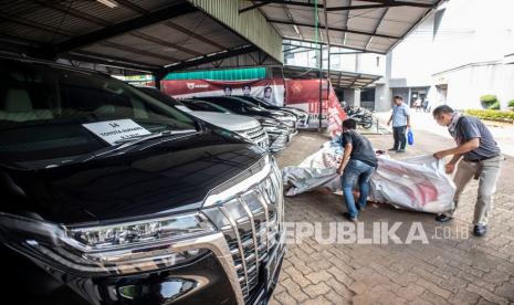 Pengamat Kritisi Lelang Aset Jiwasraya-Asabri. Foto:   Petugas memasang penutup di dekat kendaraan sitaan milik tersangka kasus dugaan korupsi PT ASABRI (Persero) di Kantor Pusat PT ASABRI (Persero), Cawang, Jakarta, Sabtu (12/6/2021). Kejaksaan Agung melelang 16 mobil kelas menengah hingga mewah hasil sitaan terkait kasus dugaan korupsi PT ASABRI (Persero) yang akan dilakukan pada 15 Juni 2021 pukul 09.00-11.00 WIB pada laman www.lelang.go.id. 