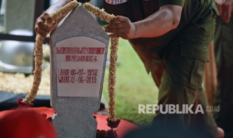 Petugas memasang rangkaian bunga melati pada nisan makam istri Presiden ke-6 RI Susilo Bambang Yudhoyono, Kristiani Herawati atau Ani Yudhoyono dalam upacara pemakaman di Taman Makam Pahlawan (TMP) Kalibata, Jakarta Selatan, Ahad (2/6/2019).