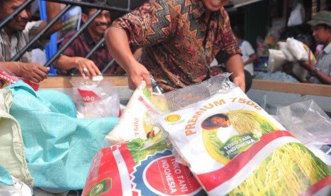 Petugas memasok permintaan produk beras lokal Sumatera Selatan kepada sejumlah pedagang di Toko Tani Pasar Gubah Palembang, Senin (28/3).