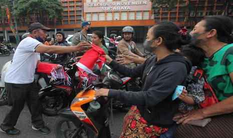 Petugas membagikan bendera Merah Putih kepada warga di kawasan Tambaksari, Surabaya, Jawa Timur, Rabu (10/8/2022). Pemkot Surabaya membagikan sekitar 13.884 bendera Merah Putih kepada warganya yang dilakukan serentak di wilayah Surabaya dalam rangka menyambut peringatan HUT Kemerdekaan RI yang ke-77. 