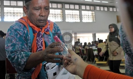 Petugas membagikan botol semprot (Spray) kepada calon jamaah haji di Asrama Haji Pondok Gede, Jakarta, Jumat (28/8).  (Republika/Rakhmawaty La'lang)