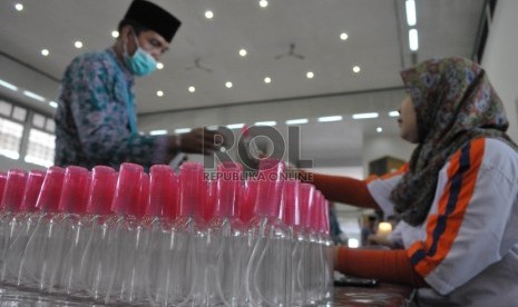 Petugas membagikan botol semprot (Spray) kepada calon jamaah haji di Asrama Haji Pondok Gede, Jakarta, Jumat (28/8).  (Republika/Rakhmawaty La'lang)