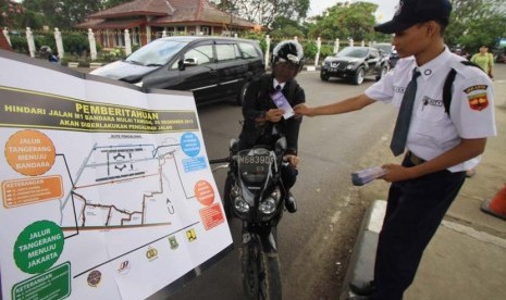 Petugas membagikan brosur sosialisasi pengalihan arus lalu lintas M1 Bandara Soekarno-Hatta, Tangerang, Banten, Selasa (24/12).   (Antara/Rivan Awal Lingga)