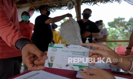 Petugas membagikan buku tabungan sampah (ilustrasi). Kementerian Kelautan dan Perikanan (KKP) melalui Direktorat Jenderal Pengelolaan Ruang Laut (Ditjen PRL) segera mengkolaborasikan program Bulan Cinta Laut (BCL) dengan PT Semen Padang melalui program Nabung Sarok (menabung sampah).