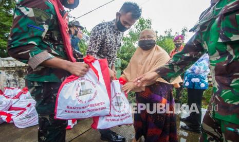 Petugas membagikan paket bantuan sembako Presiden Joko Widodo kepada warga di Desa Pekauman Ulu, Kabupaten Banjar, Kalimantan Selatan, Senin (18/1/2021). Paket bantuan tersebut dibagikan langsung kepada warga yang menjadi korban banjir saat presiden meninjau bencana di Kalimantan Selatan tersebut. 