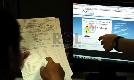   Petugas membantu mengisikan SPT pajak secara e-filing di Kantor Pusat Ditjen Pajak, Jakarta.   (Republika/Wihdan Hidayat)